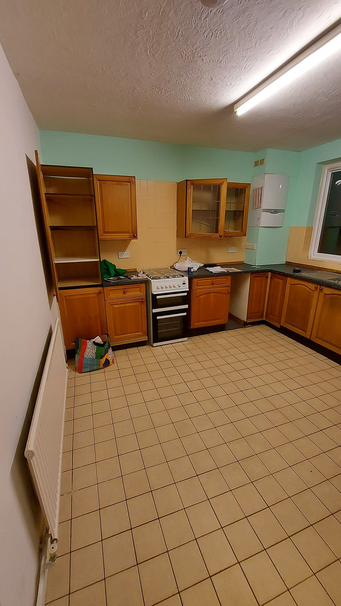 90s kitchen with wooden units and dated floor tiles